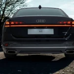 Close-up achteraanzicht van 2026 Audi A6 met OLED-achterlichtstrook, doorlopende lichtbalk, dubbele uitlaatopeningen en A6-badge
