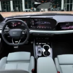 Breed interieurzicht van 2026 Audi A6 met complete cabine-indeling met drie digitale schermen, voorstoelen, middenconsole en moderne designelementen