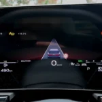 Bestuurderszicht op het digitale display van de 2026 Audi A6 met lane keeping assist graphics, snelheidslimietherkenning, navigatiepijlen en rijmodus-indicatoren
