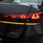 Gedetailleerd zicht op 2026 Audi A6 OLED-achterlicht met verlichte driehoekige patronen, lichtbalk en quattro-badge met geavanceerde lichttechnologie