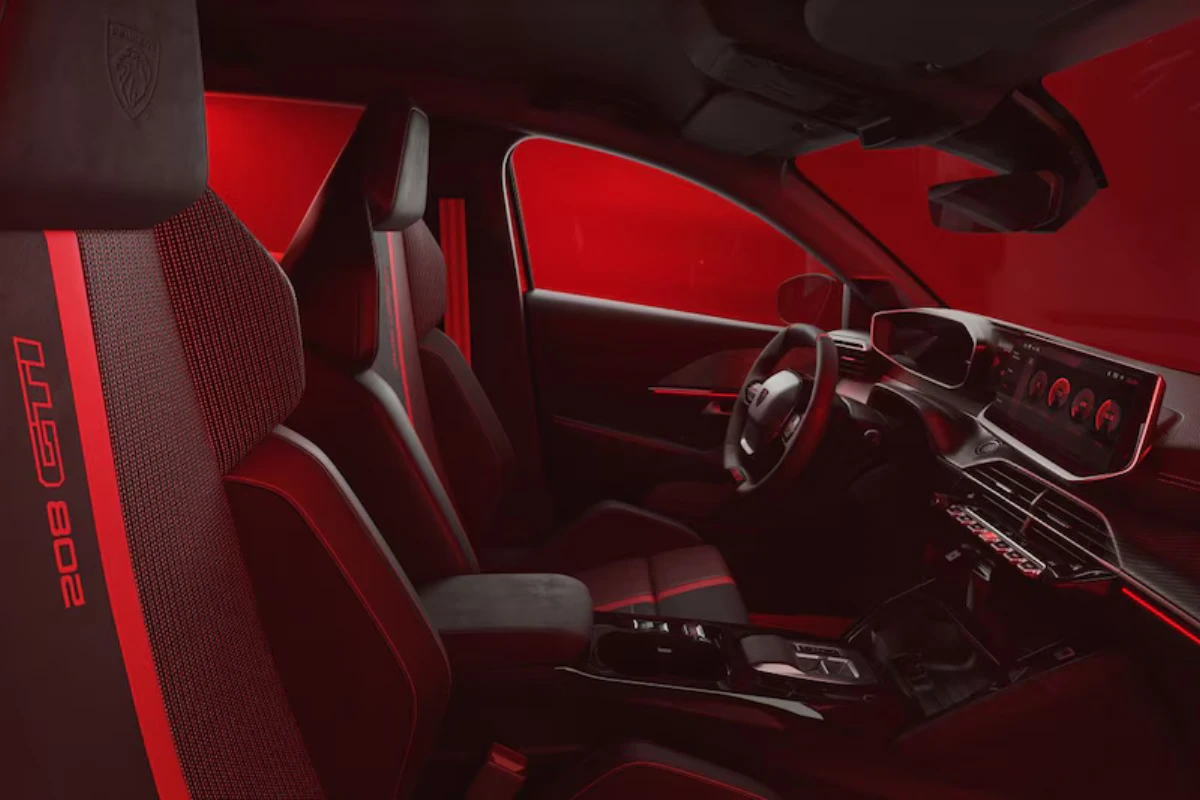 Zijaanzicht van complete 2026 Peugeot e-208 GTi interieur met voor- en achterstoelen met rode accenten, sfeerverlichting, dashboard, en algemene cabine-indeling