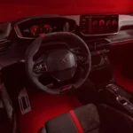 Dashboard aanzicht van 2026 Peugeot e-208 GTi met digitaal instrumentencluster met rode graphics, centraal touchscreen, versnellingspook, en premium interieur materialen
