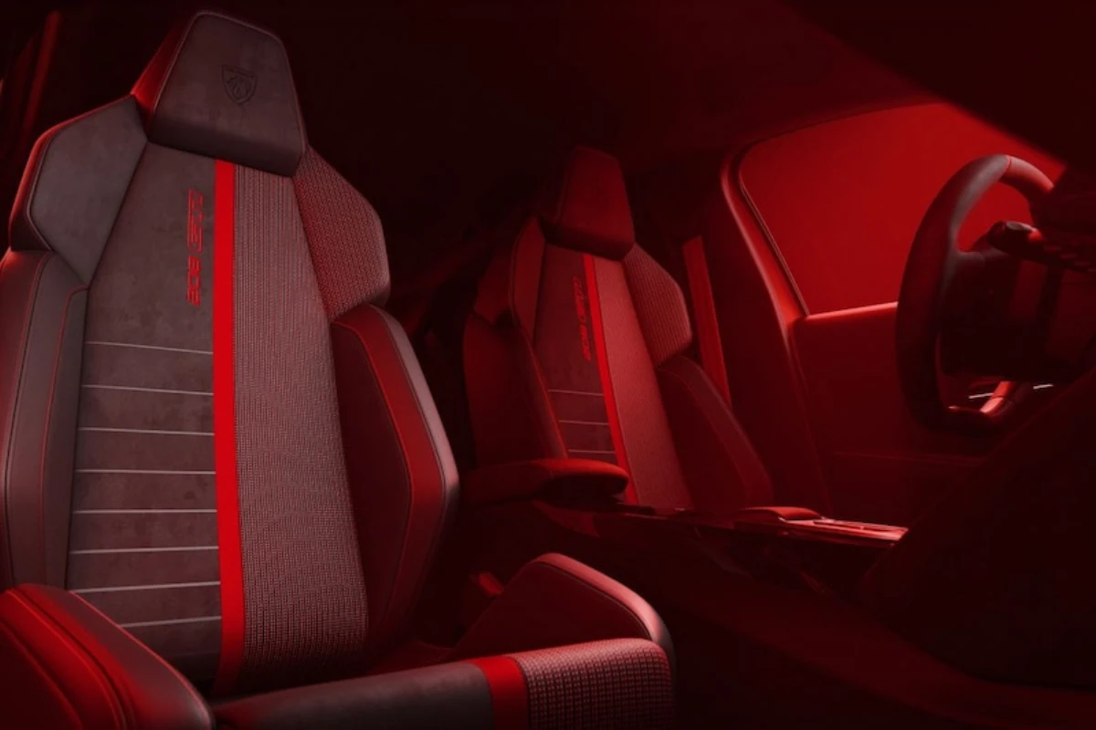 Achterbank aanzicht van 2026 Peugeot e-208 GTi interieur met achterstoelen met rode streep details, sfeerverlichting, en algemene achterpassagier ruimte