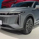 Voorkant driekwart zicht van zilveren Omoda 09 op autoshow met 134 LED dagrijverlichting, diamant-patroon grille, gedurfd voorbumper ontwerp en 20-inch lichtmetalen velgen met zichtbaar Omoda logo