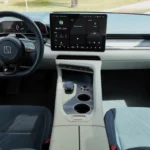 Zeekr 001 elektrische voertuig dashboard met groot touchscreen display, digitaal instrumentencluster, stuurwiel met haptische bediening, en premium interieurmaterialen in blauw en crème kleuren
