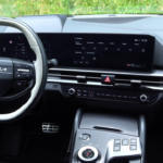 2026 Kia Sportage 12,3-inch touchscreen met infotainment interface, klimaatregelaars eronder en roterende versnellingspook op middenconsole