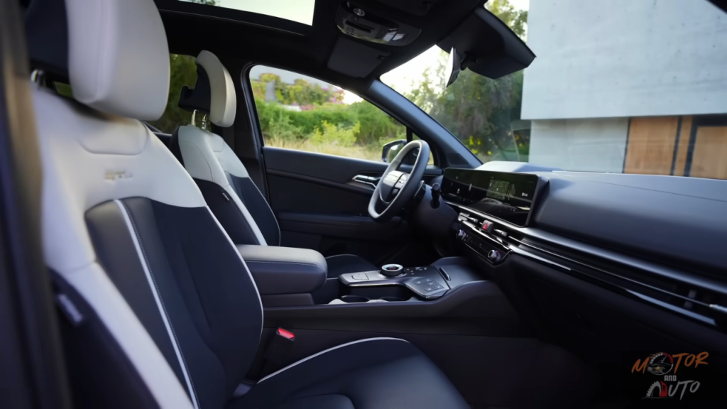 2026 Kia Sportage GT-Line interieur met voorstoelen in wit en zwarte tweekleurige bekleding, panoramadak erboven en premium dashboard materialen