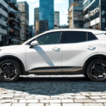 2026 Kia Sportage witte SUV zijaanzicht met 18-inch zwarte lichtmetalen velgen, zijpaneel bescherming, deurgrepen en compacte SUV silhouet op klinker bestrating met stedelijke architectuur