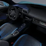 Zijkant interieur aanzicht van 2026 Maserati MCPura met gedetailleerde laser-geëtste Alcantara stoelpatronen met blauwe accent lijnen, zwarte suède dashboard afwerking, en premium Italiaans vakmanschap door de hele cabine
