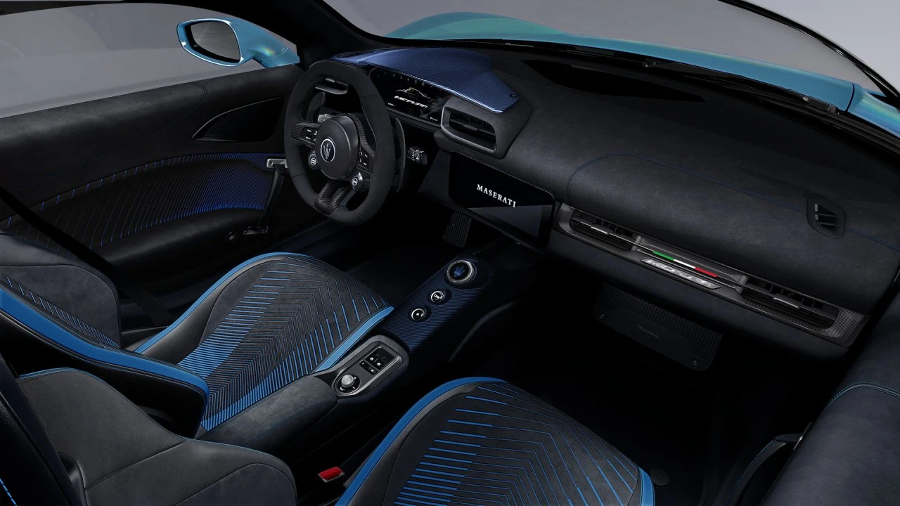 Zijkant interieur aanzicht van 2026 Maserati MCPura met gedetailleerde laser-geëtste Alcantara stoelpatronen met blauwe accent lijnen, zwarte suède dashboard afwerking, en premium Italiaans vakmanschap door de hele cabine
