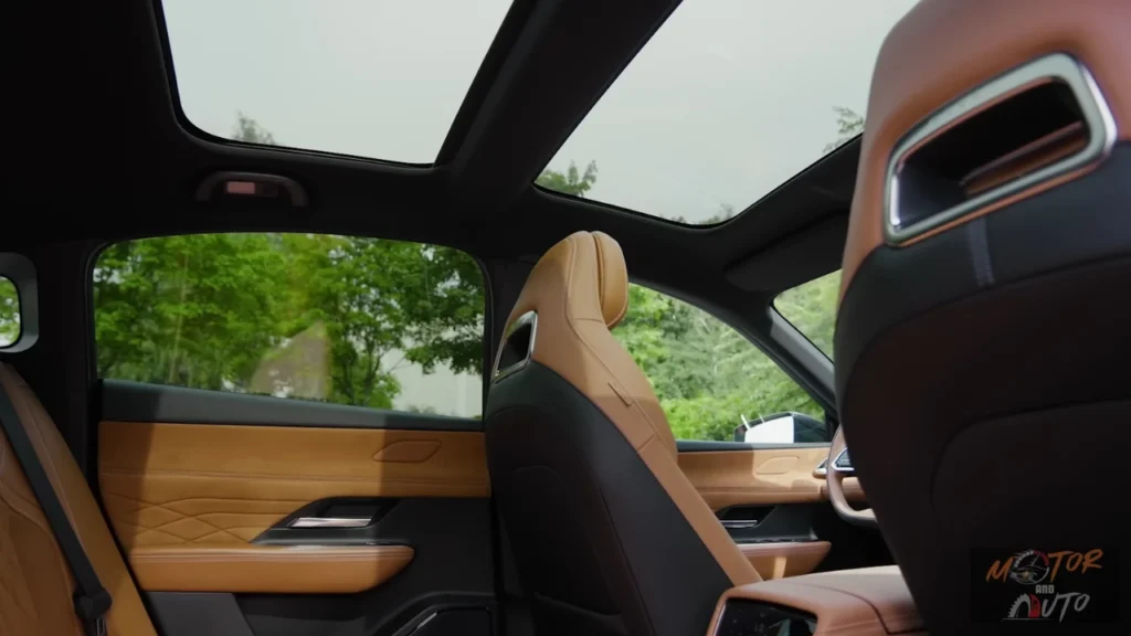 2026 Mazda 6e panoramadak zicht vanuit achterbank met split-paneel ontwerp, elektrisch zonnescherm, en premium tan leder interieur in Takumi Plus uitvoering