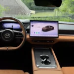2026 Mazda 6e volledig dashboard overzicht met geavanceerd infotainment systeem, voertuig instellingen, en premium tan leder interieur integratie