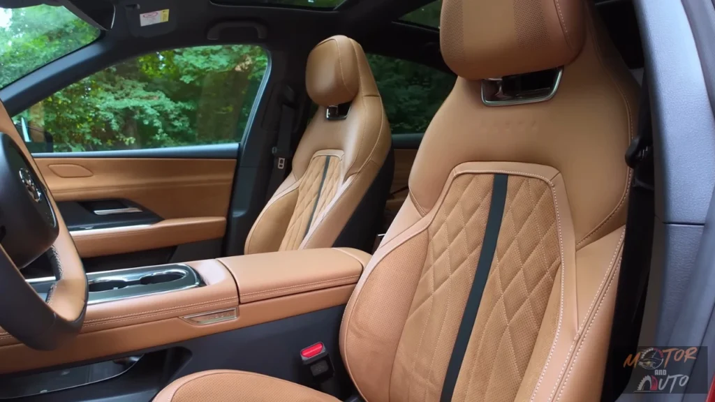 2026 Mazda 6e voorstoelen close-up met gestikt tan Nappa leder bekleding met suède inzetstukken en premium stikwerk details in Takumi Plus uitvoering