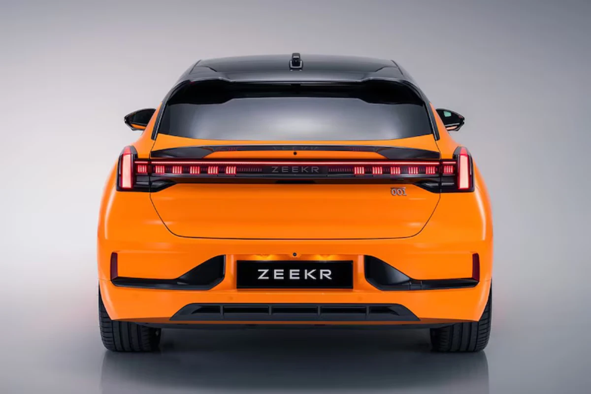 Zeekr 001 Sport Edition achteraanzicht met carbon fiber spoiler, brede LED achterlichtstrip, Speed Orange lak, ZEEKR badge en shooting brake achterprofiel op studio achtergrond