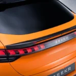 Gedetailleerd aanzicht van Zeekr 001 Sport Edition carbon fiber achterspoiler met geïntegreerde LED achterlichten, Speed Orange lakafwerking en premium carbon fiber weefselstructuur
