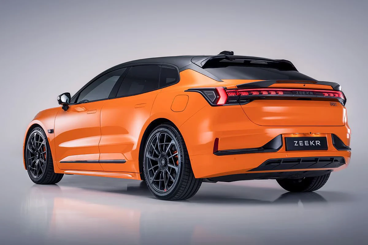 Zeekr 001 Sport Edition schuin achteraanzicht met compleet designpakket inclusief 22-inch zwarte velgen, carbon spoiler, oranje remklauwen, Speed Orange lak en luxe shooting brake verhoudingen