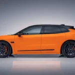 Compleet zijprofiel van Zeekr 001 Sport Edition met luxe shooting brake verhoudingen, 22-inch zwarte velgen met oranje remklauwen, carbon spiegelkappen, Speed Orange lak met zwart dak