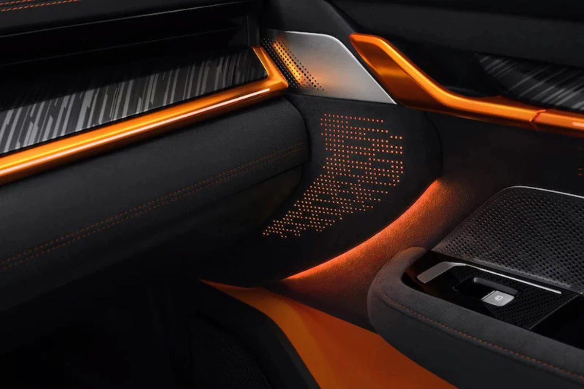 Close-up van Zeekr 001 Sport Edition interieur ambiënt oranje verlichting, premium zwarte oppervlakken, geperforeerde patronen en exclusieve oranje accent illuminatie die luxe atmosfeer creëert