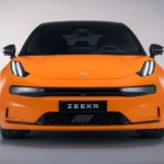Zeekr 001 Sport Edition elektrische shooting brake voorkant met Speed Orange lak, onderscheidende LED koplampen, zwarte grille en ZEEKR badge op neutrale studio achtergrond