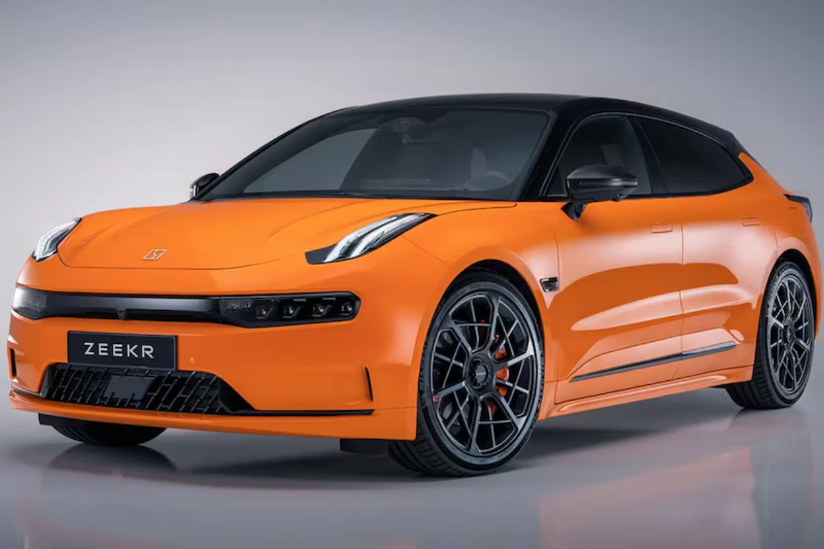 Zeekr 001 Sport Edition schuin vooraanzicht met 22-inch zwarte velgen met oranje remklauwen, Speed Orange lak, carbon fiber voorspoiler elementen en shooting brake silhouet