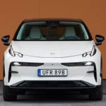 Vooraanzicht van witte Zeekr X elektrische SUV met moderne LED-koplampen, strakke designlijnen en kenteken UFR 89B tegen oranje achtergrond