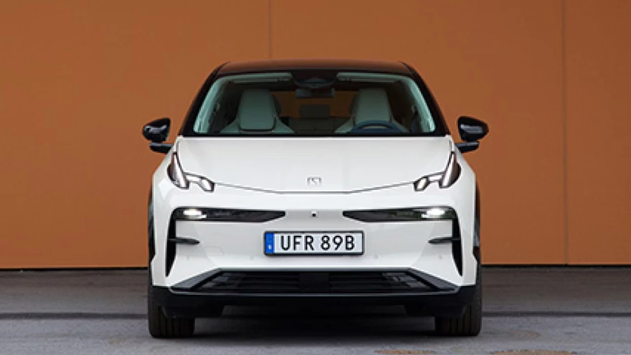 Vooraanzicht van witte Zeekr X elektrische SUV met moderne LED-koplampen, strakke designlijnen en kenteken UFR 89B tegen oranje achtergrond
