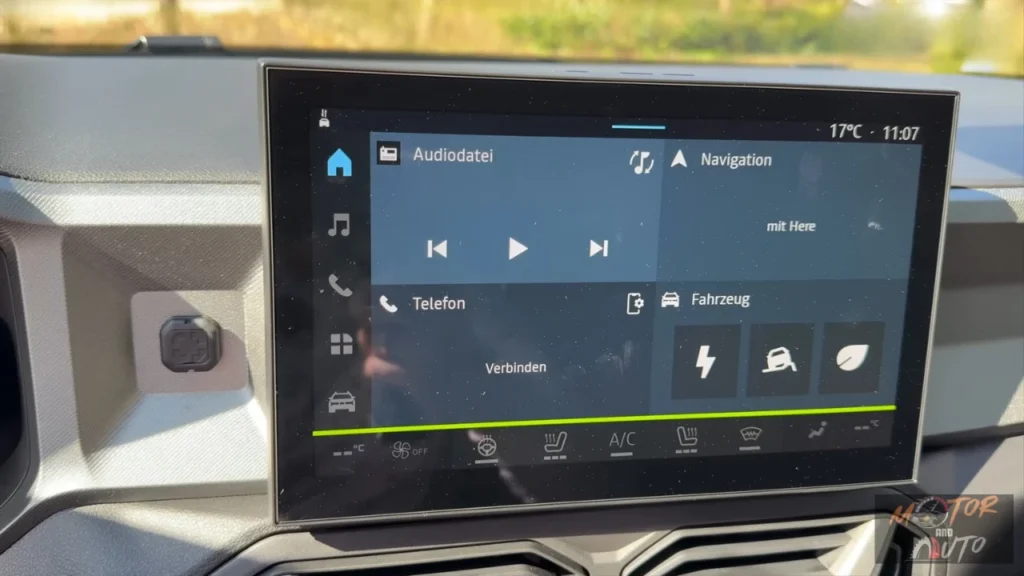 Centrale touchscreen display van 2025 Dacia Bigster met Duitse interface, mediabediening, telefoonconnectiviteit, navigatieopties en klimaatregelingsknoppen eronder