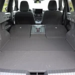Interieur bagagegebied van 2025 Dacia Bigster met volledig plat neergeklapte achterstoelen die een grote vlakke laadvloer creëren van achterklep tot voorstoelen, waarbij maximale opbergconfiguratie wordt getoond