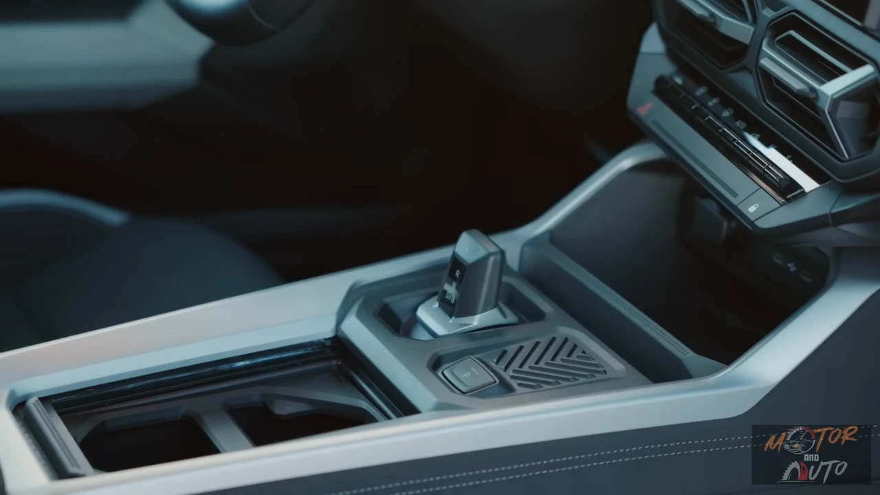 Middenconsole van 2025 Dacia Bigster met handmatige versnellingspook, bekerhouders, opbergvakken en gestructureerde oppervlakken met praktische designelementen