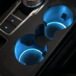 2025 Ford Kuga middenconsole bekerhouders met blauwe sfeer LED verlichting en draadloze telefoon oplaad functionaliteit, die premium interieur verlichtingsontwerp toont