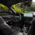 2025 Ford Kuga dashboard met het grote 13,2-inch SYNC 4 infotainment touchscreen, 12,3-inch digitaal instrumentenpaneel en leren stuurwiel met rode stiksels