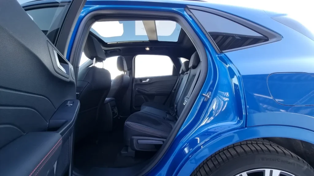 2025 Ford Kuga met passagiersdeur open die ruime interieurcabine, comfortabele zitarrangement en praktische deuropenhoek voor gemakkelijke toegang in stedelijke omgeving toont