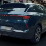 Achter drie-kwart straataanzicht van blauwe Opel Grandland met moderne designtaal en premium velgontwerp