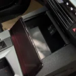 Draadloze telefoonlaadpad met transparante afdekking en USB-C-poorten in middenconsole opbergvak