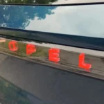 Close-up van verlichte rode OPEL-letters op achterklep