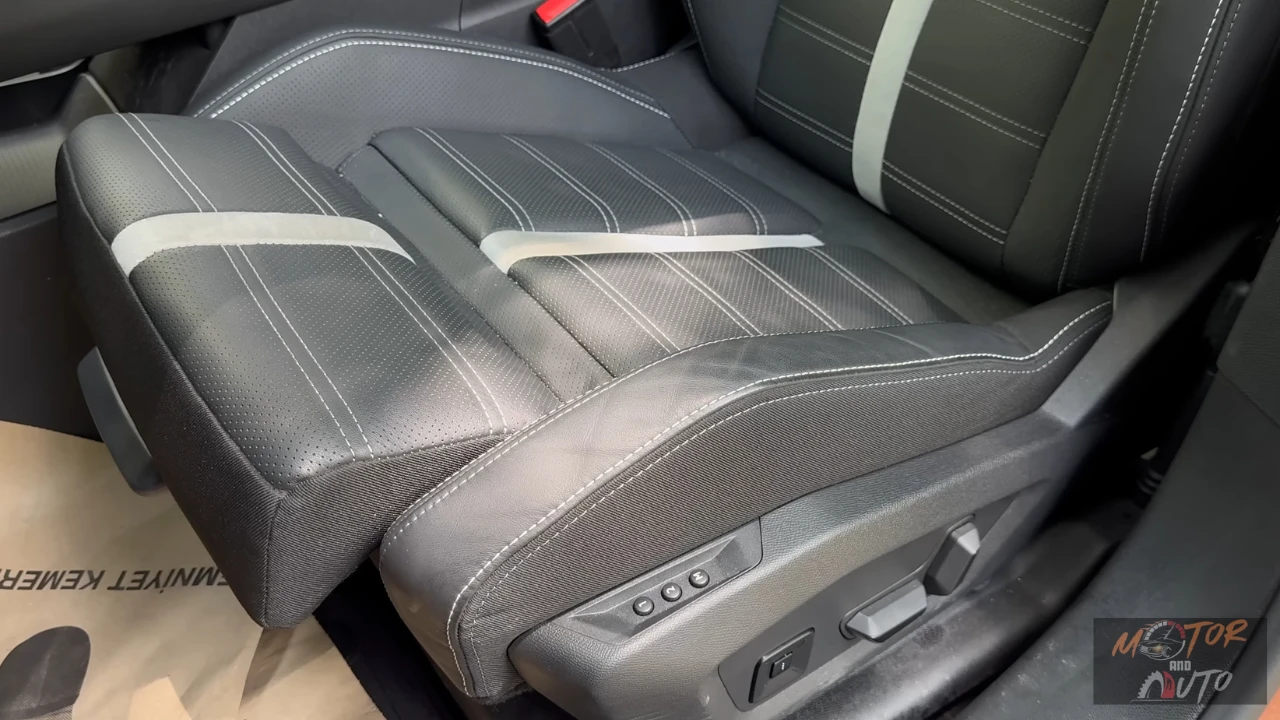 Close-up van Opel Grandland voorstoel met elektrische verstelknoppen, gestikt bekledingspatroon en comfortfuncties