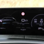 Digitaal dashboard display van de 2025 Peugeot 5008 met auto omtrek met snelheid 58 km/h, verbruik 6,4 L/100, bereik 1032 km en snelheidslimiet 90