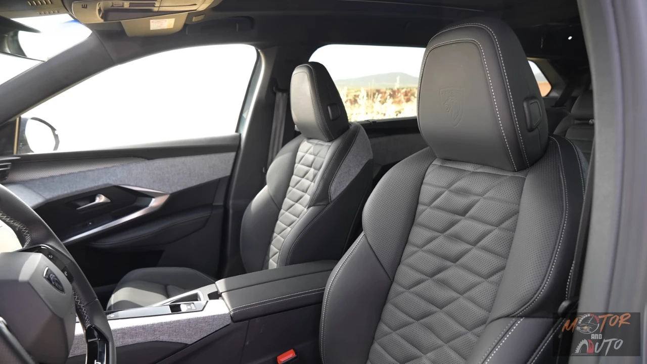 Interieurzicht van de voorstoelen van de 2025 Peugeot 5008 met gestikt bekledingspatroon en panoramadak erboven