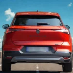 Achteraanzicht van 2025 Renault Symbioz op snelweg met LED achterlichten, SYMBIOZ badge en aerodynamisch achterontwerp