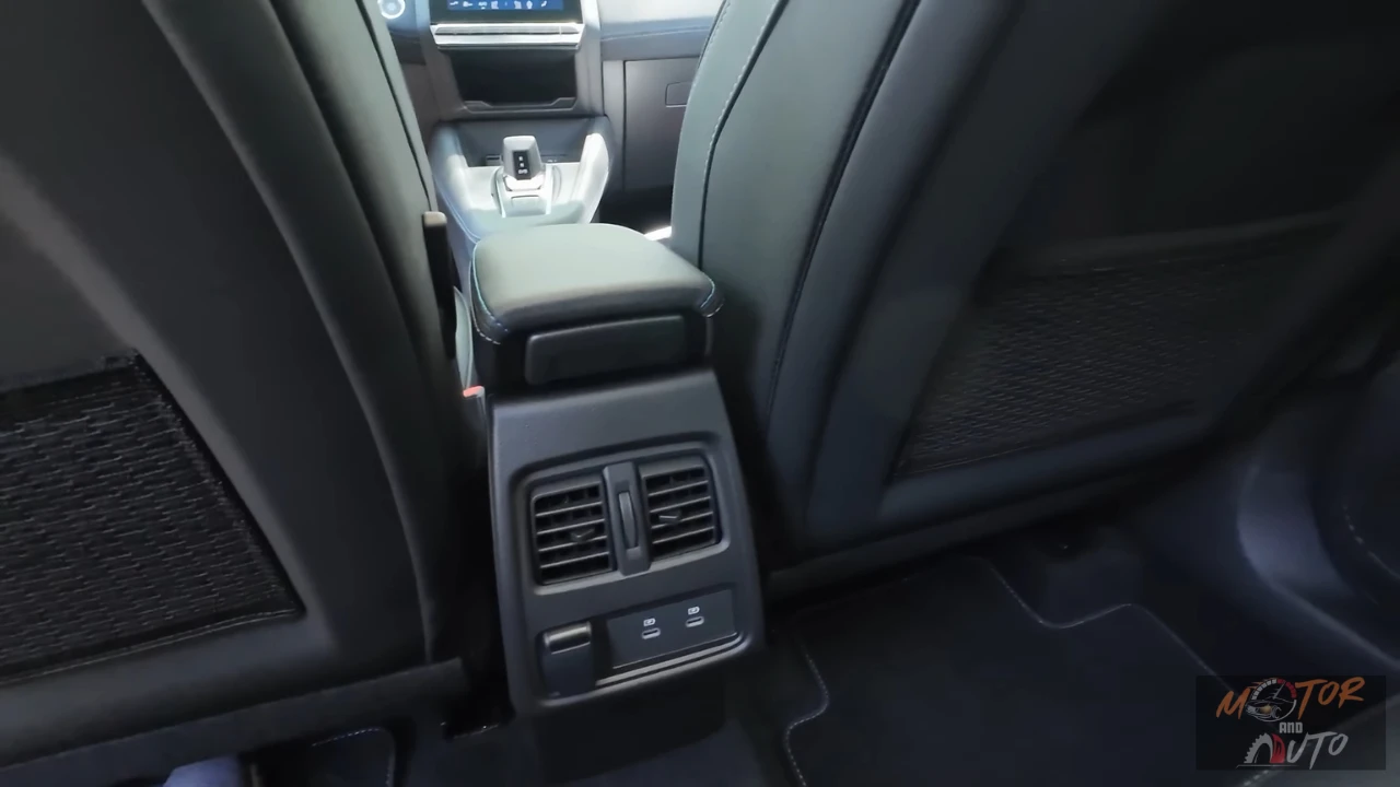 Achterpassagiers bedieningsgebied in de 2025 Renault Symbioz met klimaatbedieningsroosters, dubbele USB-C oplaadpoorten en 12V stromaansluiting voor verbeterd passagierscomfort en connectiviteit.