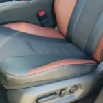 2025 Suzuki e Vitara bestuurdersstoel detail met bruine en zwarte bekleding en elektrische stoelverstelling