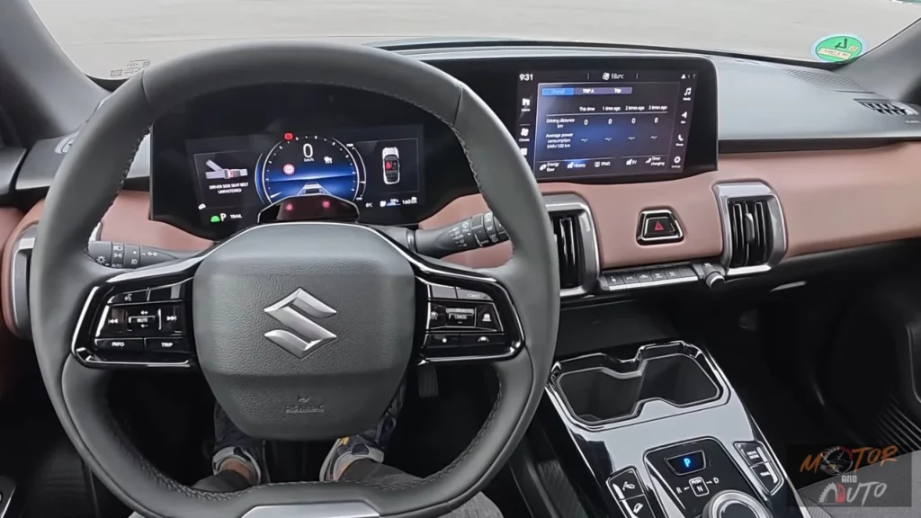 Bestuurdersview van de 2025 Suzuki e Vitara met leren stuurwiel met bedieningselementen en 10,25-inch digitaal instrumentarium