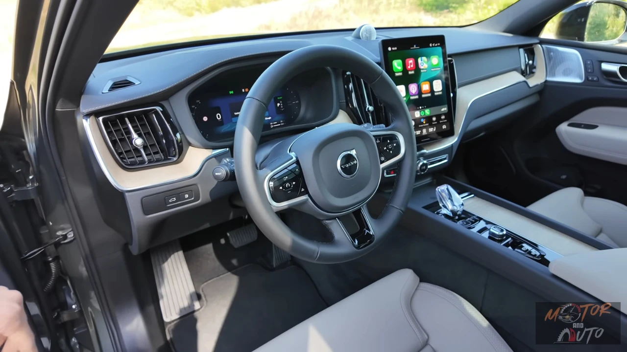 2026 Volvo XC60 bestuurders gezichtspunt met Apple CarPlay op touchscreen, digitaal dashboard en stuurwiel vanuit bestuurdersstoel perspectief