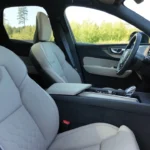 2026 Volvo XC60 compleet interieur overzicht met panoramadak, lichtgrijze Nordico stoelen, natuurlijke hout dashboard afwerking en ruime vijf-persoons cabine indeling