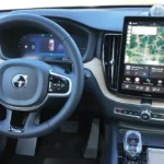 2026 Volvo XC60 infotainment touchscreen met Google Maps, klimaatbediening interface en geavanceerde connectiviteitsvoorzieningen met kristallen versnellingspook zichtbaar
