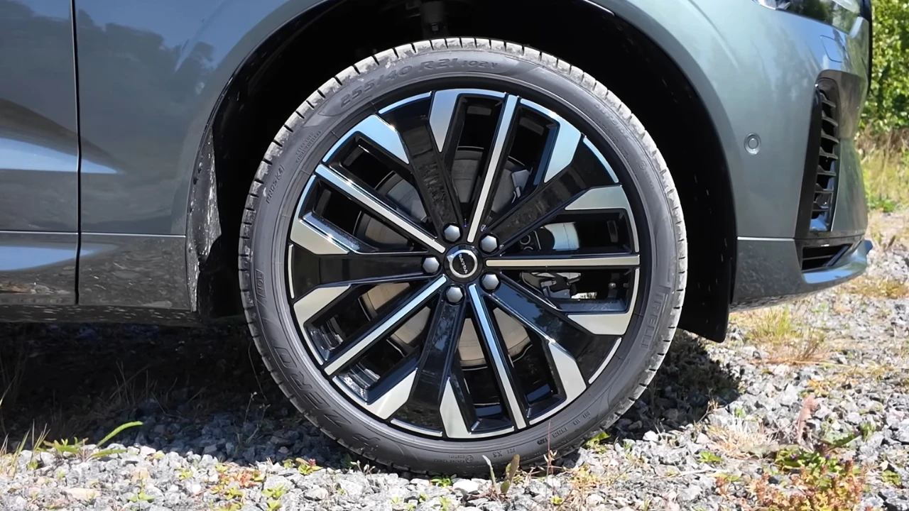 2026 Volvo XC60 gedetailleerde lichtmetalen velg close-up met meerspaaks ontwerp, zwart en zilver afwerking en remssysteem detail