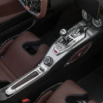 Gedetailleerd zicht van Hennessey Venom F5 Revolution LF handgeschakelde transmissie versnellingspook met H-patroon poort, aluminium constructie, en koolstofvezel middenconsole