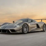 Front driekwart zicht van Hennessey Venom F5 Revolution LF op circuit met agressieve front aerodynamica, champagne lak, en circuit-gerichte ontwerp elementen