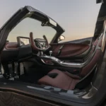 Interieurzicht van Hennessey Venom F5 Revolution LF met bruine leren stoelen, koolstofvezel dashboard, handgeschakelde versnellingspook, en bestuurder-gerichte cockpit ontwerp met vleugeldeuren open