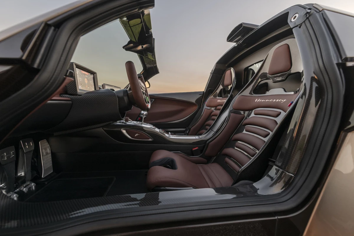 Passagierszijde interieurzicht van Hennessey Venom F5 Revolution LF met bruine leren kuipstoelen met Hennessey branding, koolstofvezel accenten, en premium cabine materialen